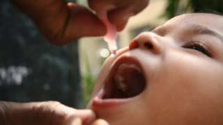 child being given oral polio vaccine