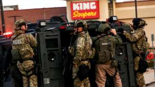 Law enforcement officers in tactical gear are seen at the site of a shooting at a King Soopers grocery store in Boulder, Colorado
