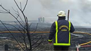 Firefighters work to extinguish a fire after the explosion at the container base in the industrial area of Matanzas Bay, Cuba, 09 August 2022.