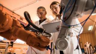 Two workers with robots