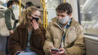 Young woman and man wearing masks on metro