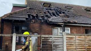 Firefighter outside a bungalow