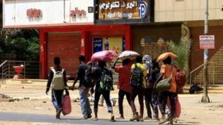 people carry belongings, khartoum 16 april