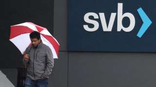 Employees walk in front of the Silicon Valley Bank (SVB) headquarters in California
