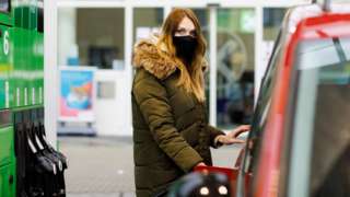 Woman filling up car with petrol.