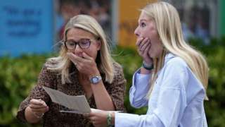 A GSCE student receives her results with her mum
