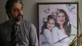 Dr. Hamed Esmaeilion, wears a pin with the faces of the wife and daughter