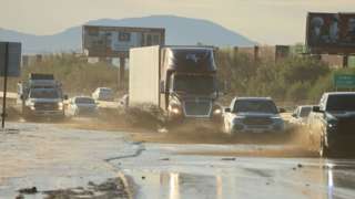 Traffic is slowed as water and mud from Tropical Storm Hilary covers part of Interstate 10, between Indio and Palm Springs, California