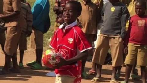 A young boy in Rwanda playing rugby