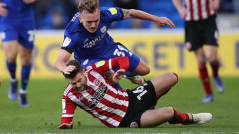 Isaak Davies of Cardiff City is tackled by Ollie Norwood of Sheffield United