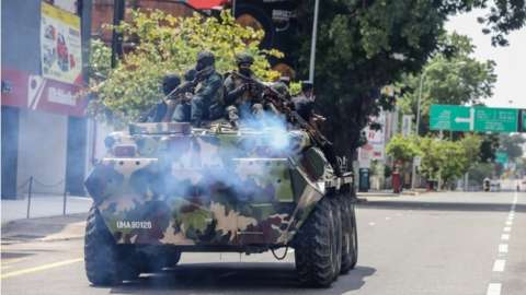 Armed military personnel patrol during an island-wide curfew amid political unrest in Colombo, Sri Lanka, 11 May 2022.