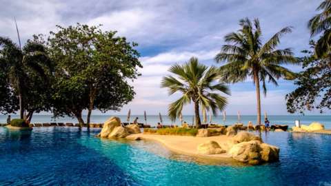 The pool of a tourist resort, surrounded by palm trees, at White Sand Beach on Koh Chang.