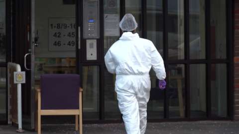 Screengrab taken from a PA Video of a scenes of crime officer (SOCO) at the scene where three people were found dead in a "targeted attack" at a home in a village in Buckinghamshire.