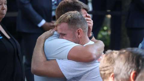 Two 9/11 mourners embrace