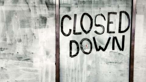 Image of shop front with closed down sign.