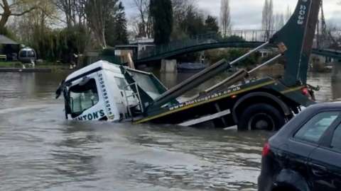 Skip lorry slipping into the River Thames
