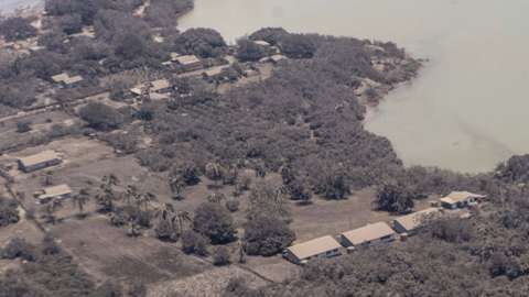 Photos released by the New Zealand Defence Force showed the coast of Tonga blanketed in ash