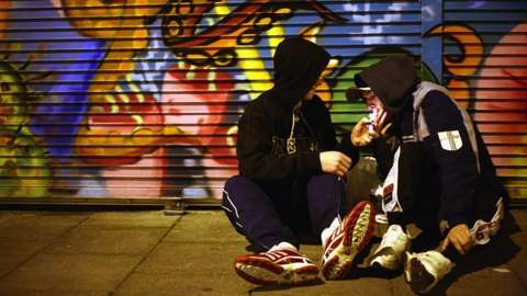 Youths with hoods at night