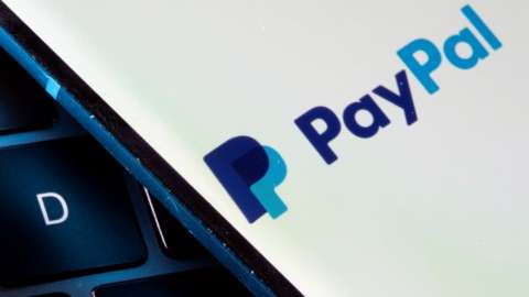 PayPal logo on a phone sitting against a keyboard in close-up