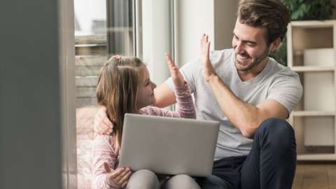 A father and daughter congratulate one another whilst learning