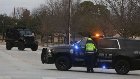 Law enforcement vehicles are seen in the area where a man has reportedly taken people hostage at a synagogue