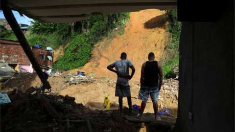 Men stand on the debris of a house which collapsed during a landslide caused by heavy rains at at Jardim Monte Verde, in Ibura neighbourhood, in Recife, Brazil, May 30, 2022