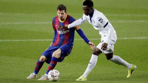 Getafe's Ghanaian midfielder Sabit Abdulai (right) tries to tackle Barcelona's Lionel Messi