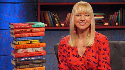 Sara Cox with a pile of books