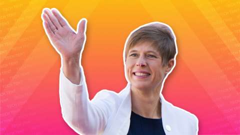 President Kersti Kaljulaid waves, cut out against a bright background in the Tech Tent orange and magenta brand colours