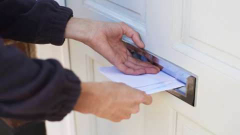 Postal worker delivering letter