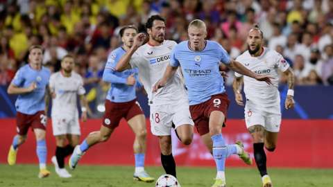 Manchester City's Erling Haaland evading two Sevilla defenders