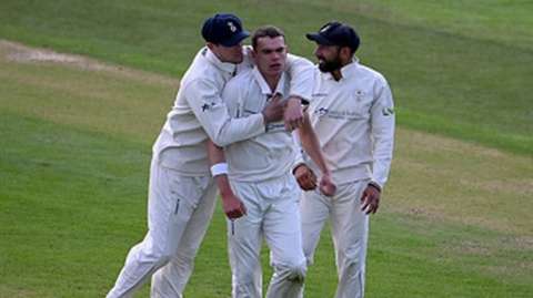 Sam Conners (centre) is congratulated by team-mates after taking the wicket of Harry Swindells