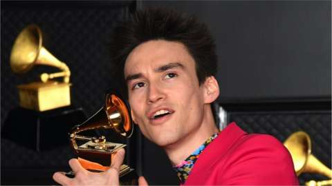 Jacob Collier holding a Grammy