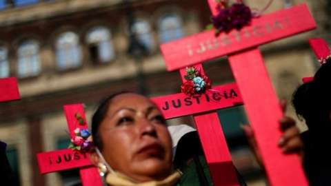 Women hold crosses in a protest against femicide and violence against women outside National Palace in Mexico City, Mexico, May 18, 2022
