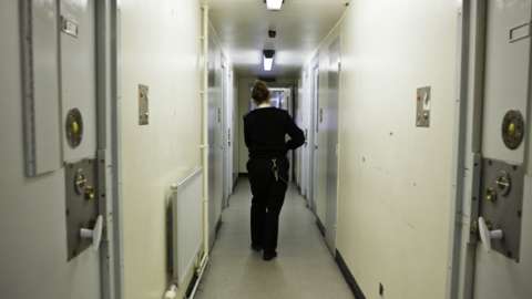 A female prison officer in a residential wing at HMP Send