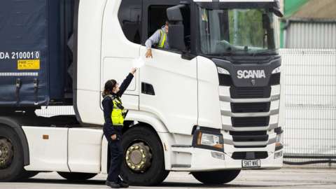A Border Force Officer returns papers to a haulage driver after checks in Northern Ireland