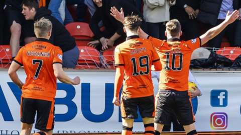 Dundee United's Nicky Clark celebrates with teammates in front of the fans after making it 1-0
