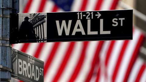 Wall Street sign and American flag