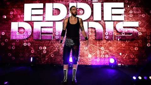 Eddie in wresting outfit coming on stage in from of Eddie Dennis sign