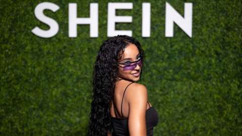 Singer Tinashe in front of Shein sign.