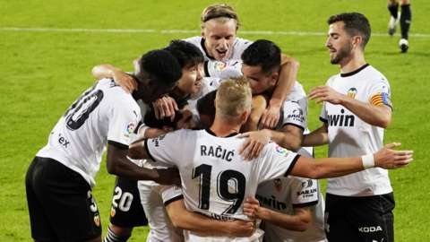 Valencia's players celebrate scoring against Real Madrid