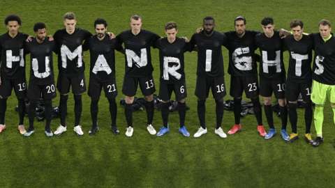 Germany's starting side link arms while wearing black t-shirts, each with a white letter on them, spelling out 'Human rights' before their 2022 World Cup qualifier against Iceland to show support for migrant workers building stadiums in Qatar