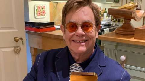 Sir Elton John with his official chart award