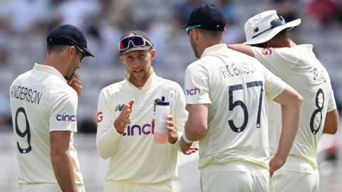 Joe Root speaks with his England players