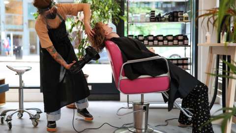 A customer has their hair cut at a salon