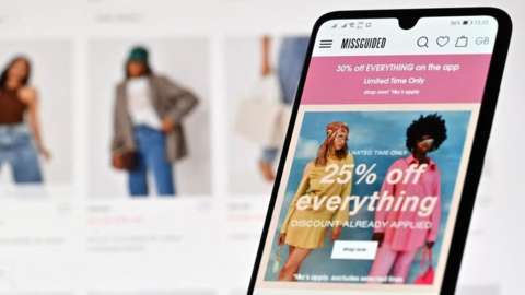 A mobile phone showing the Missguided website