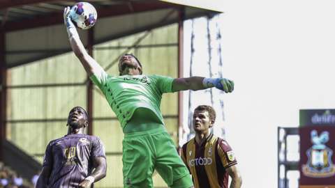 Harry Lewis of Bradford collects as Omar Bogle looks on