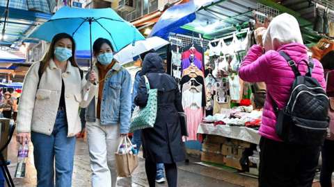 People wear masks on a street in Hong Kong on 17 February 2022