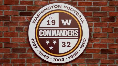 The new Washington Commanders burgundy, white and gold logo on a brick wall at their stadium