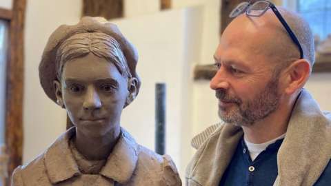Sculptor Ian Wolter with statue